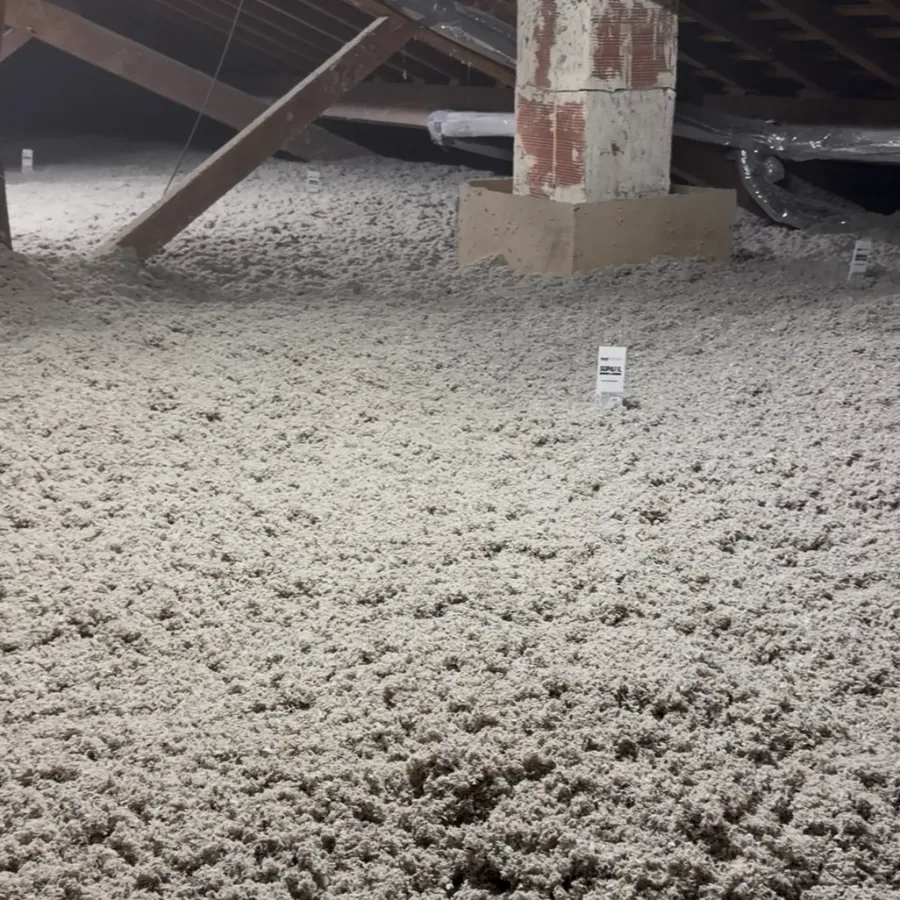 Combles après soufflage de ouate de cellulose, avec repère de hauteur d'isolant